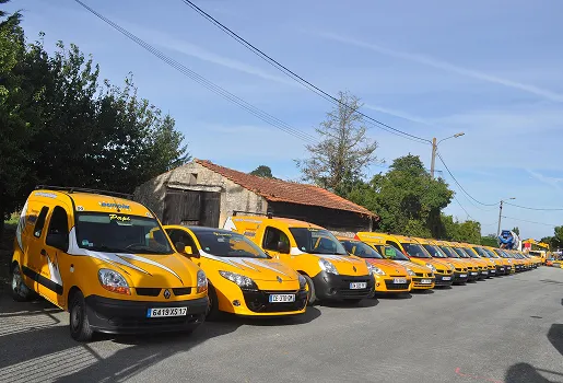 Une longue file de camionnettes jaunes Renault garées le long d'une route rurale à Corme-Royal en Charente-Maritime 17