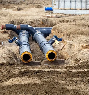 Tuyaux noirs avec raccords et vannes dans une tranchée de chantier en terre à Corme-Royal en Charente-Maritime 17