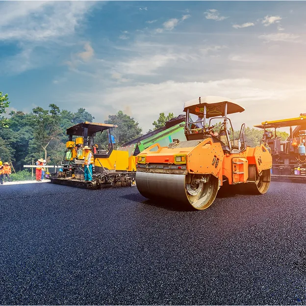 Travailleurs utilisant des machines pour poser de l'asphalte frais sur une route à Corme-Royal en Charente-Maritime 17